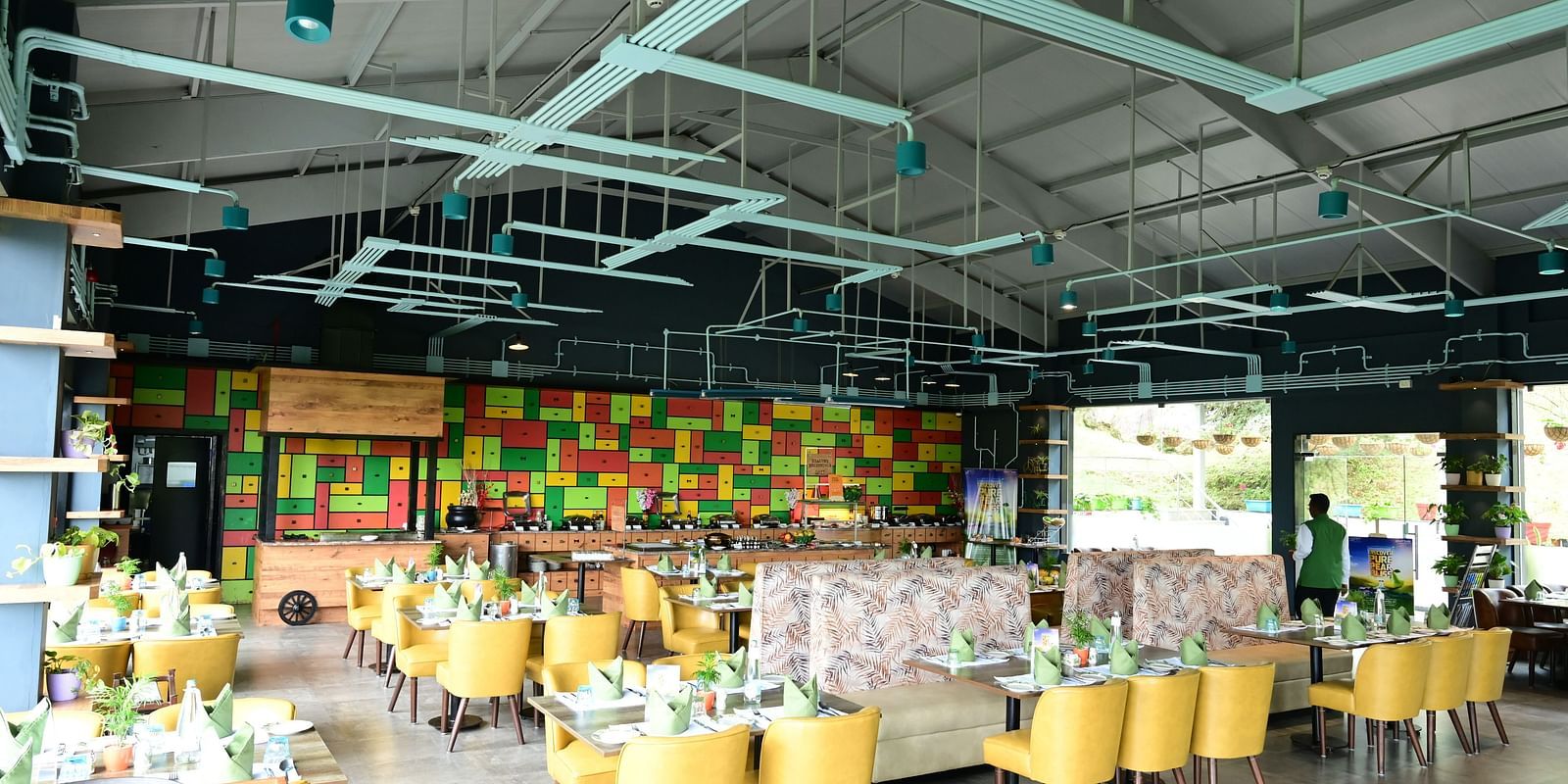 An image of a restaurant with seating arrangement, cutlery, and decorative items - GReaT trails Kodaikanal by GRT Hotels