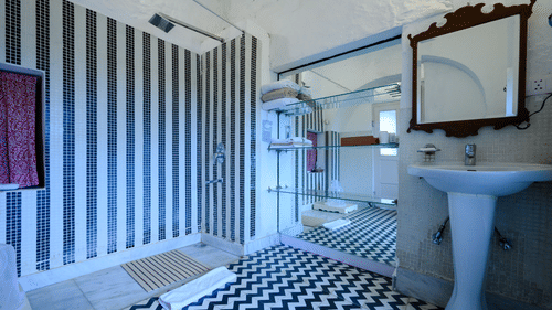 Hill Fort Kesroli 14th Century Alwar - interior view of the Mubarak bathroom featuring a wash basin, a mirror and a shower area 