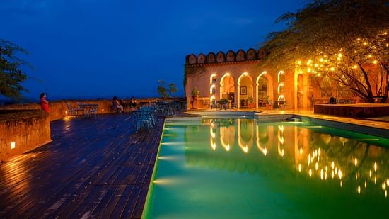 A vibrant blue pool with the resort at the background - Hill Fort Kesroli Alwar Rajasthan