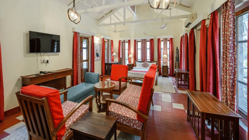 An overview of a room with a double bed and chairs in front of it - Neemrana's Glasshouse on the Ganges, Rishikesh