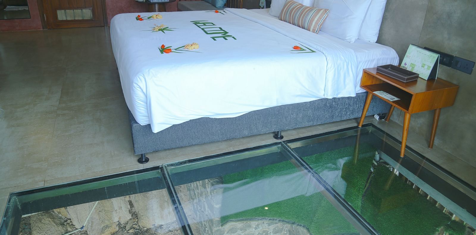 An image of a room with a panoramic view featuring king size bed, bed side table, and other modern amenities - Great Trails Yercaud by GRT Hotels
