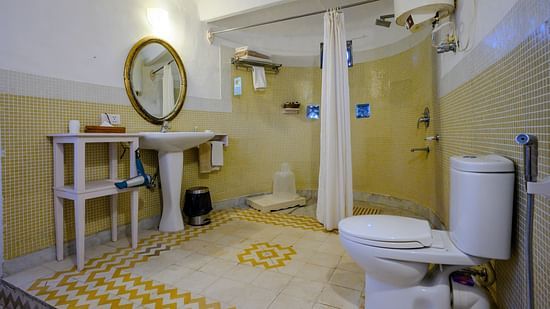 Hill Fort Kesroli 14th Century Alwar - interior view of the Raunak Mahal - Village View Bathroom featuring a commode, shower area, wash basin and a circular mirror