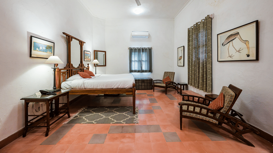 Hill Fort Kesroli 14th Century Alwar - interior view of the Rajhans Mahal - Countryside View with a  king size bed, a ceiling fan and paintings hanging on the wall