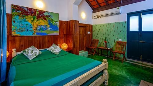 room with wall painting and green bed sheet