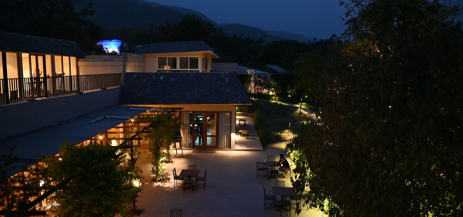 Sub-aerial view of the deck of Azrak Restaurant at Saraca Resort & Spa Corbett during blue hour