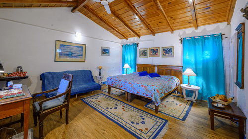 Irish bedroom with a double bed, wooden ceiling and a ceiling fan - Ramgarh Bungalows, Nainital.