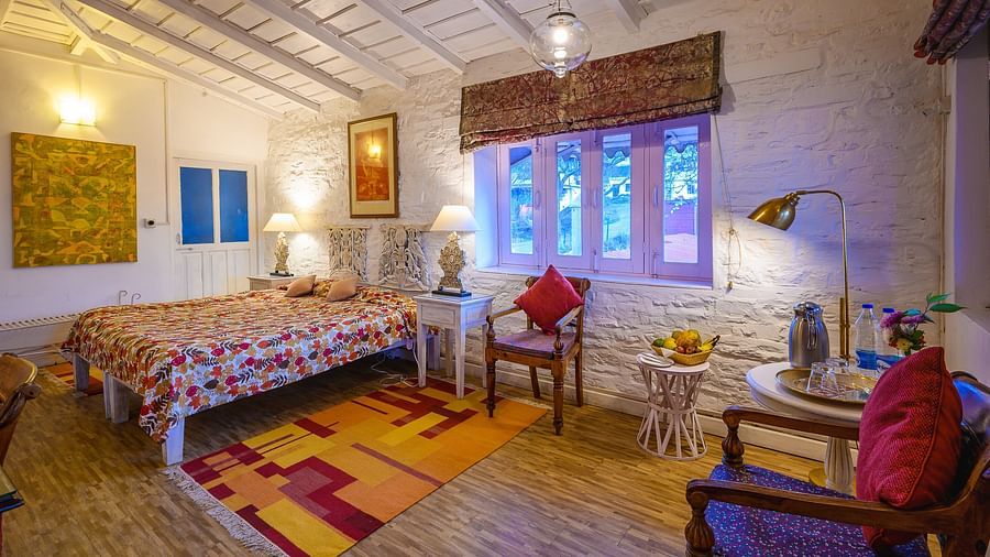 The Ramgarh Bungalows - Gitonde room corner view with night lamp and stone carved walls along with room amenities like an electric kettle, a work desk and room heater