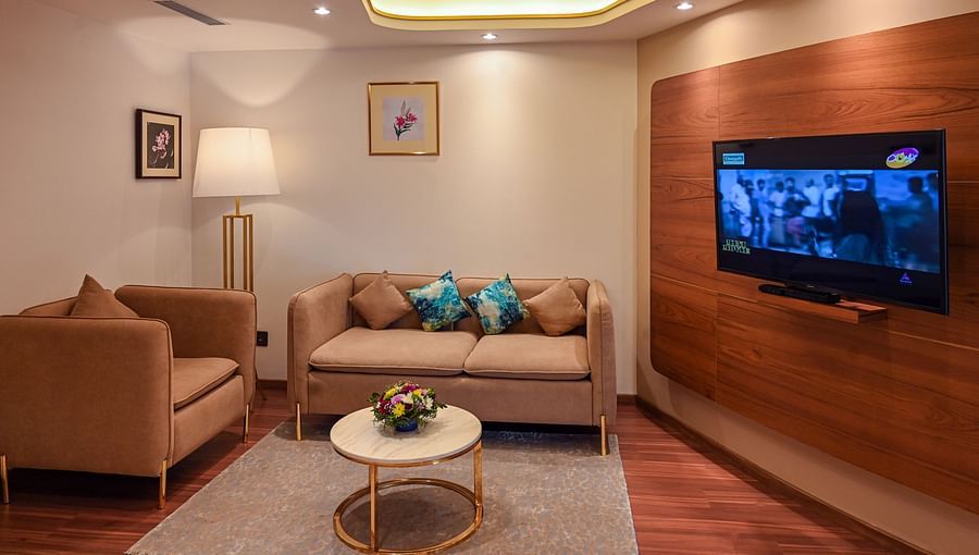 alt-text the living space with sofa set and a tv offered by the superior rooms in Kozhikode