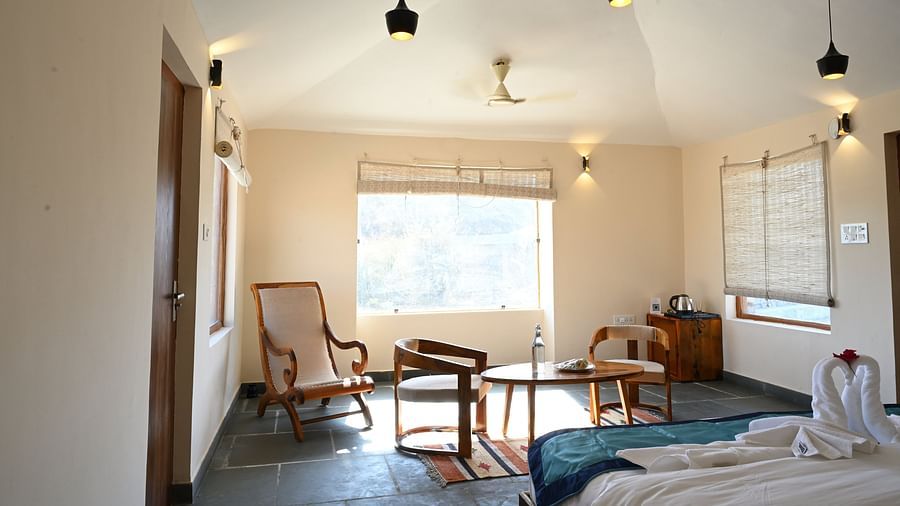Clarks Safari Jawai - the bedroom area with a chair and desk kept in front of the window at the plunge pool cottage in Jawai