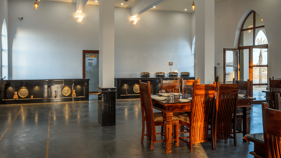 The interiors of the dining hall is equipped with wooden tables and chairs - Karwaan Jaisalmer