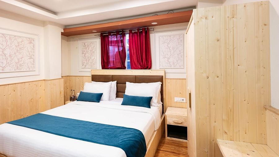 an image of a premium room with balcony featuring a scenic window behind the bed at Avianna New Mandala Hotel & Spa, Darjeeling