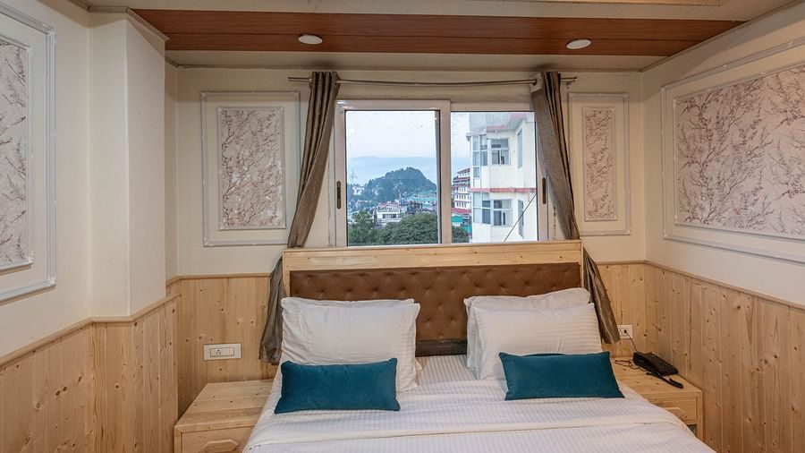 an image of a bedroom with a valley view window behind it at Avianna New Mandala Hotel & Spa, Darjeeling