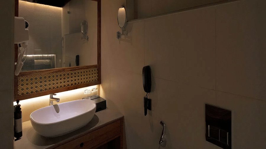 Image of bathroom of Coral Sapphire at Coral Reef Resort and Spa in Havelock featuring a sink with a mirror over it and a tiny mirror mounted on the wall next to it