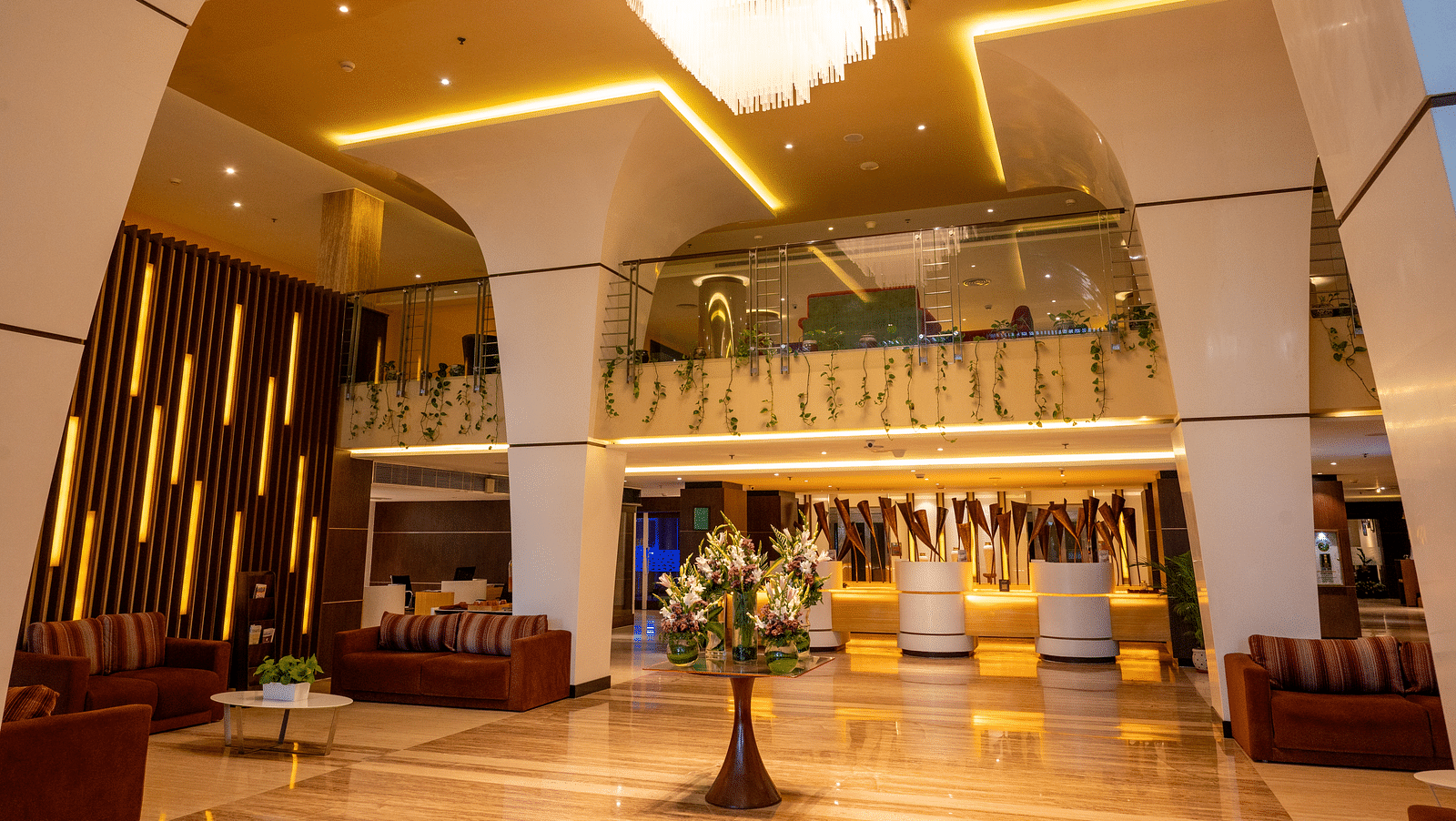 An image of lobby with a huge chandelier and well arranged sofas at Grand Kakinada by GRT Hotels