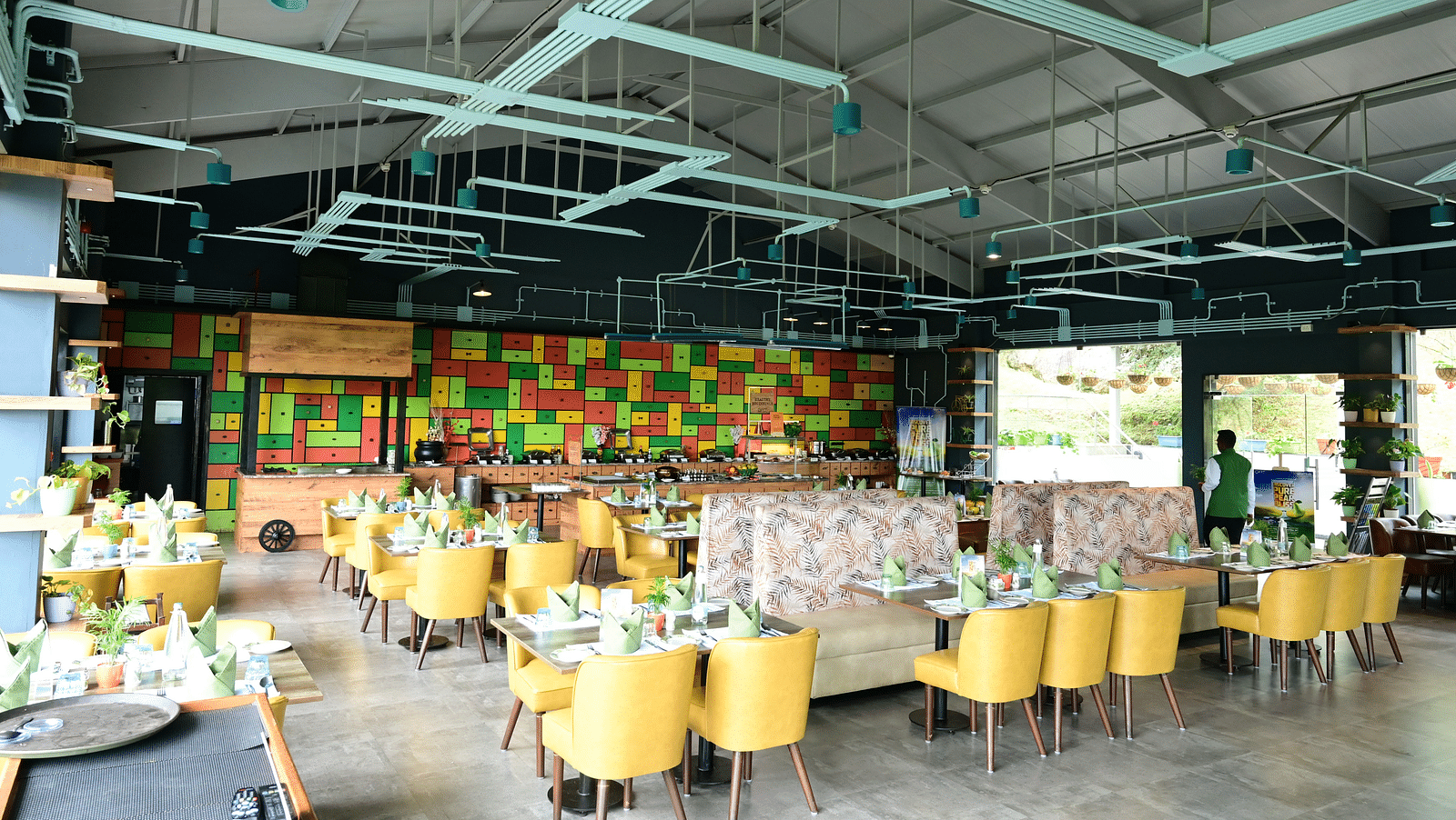 An image of a restaurant with seating arrangement, cutlery, and decorative items - GReaT trails Kodaikanal by GRT Hotels