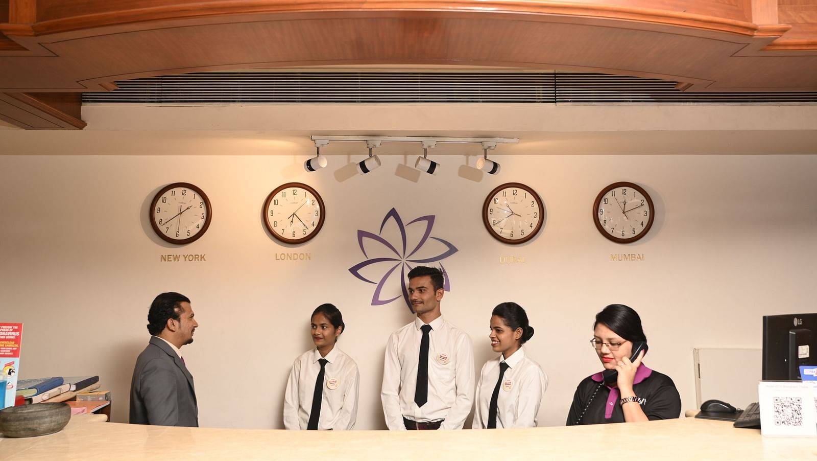 A guest interacting with the reception staff at a hotel - Kamats India