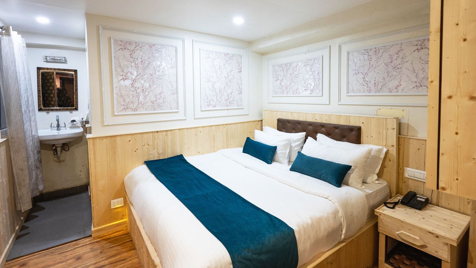an image of a standard room with a king size bed and a phone line next to it  on a table at Avianna New Mandala Hotel & Spa, Darjeeling