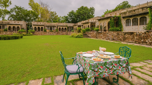 The outdoor dining area of Deo Bagh - 17th Century, Gwalior featuring a a two person seating arrangement