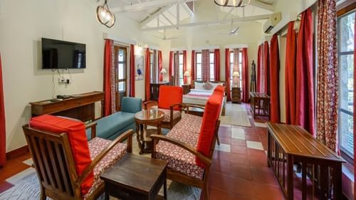 An overview of a room with a double bed and chairs in front of it - Neemrana's Glasshouse on the Ganges, Rishikesh