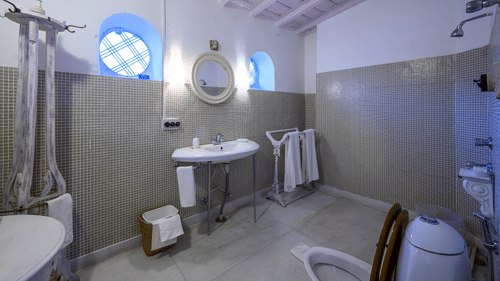 A spacious bathroom with marbled floor and water heater along with towel hanger and separate shower space - Ramgarh Bungalows, Nainital.