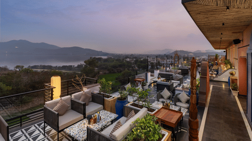  An elegant rooftop setup showcasing a breathtaking sunset over a tranquil landscape.