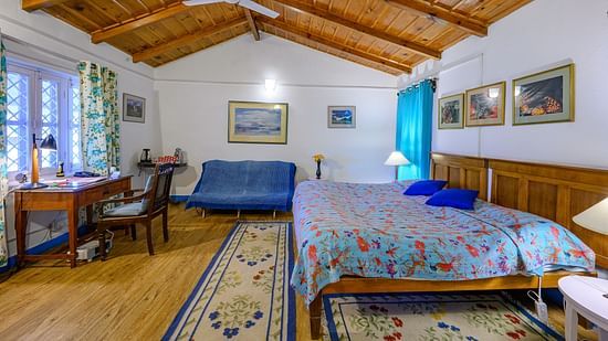 The Ramgarh Bungalows - Irish bedroom with wooden ceiling and featuring a workdesk, a couch and double queen size beds along with bedside lamps
