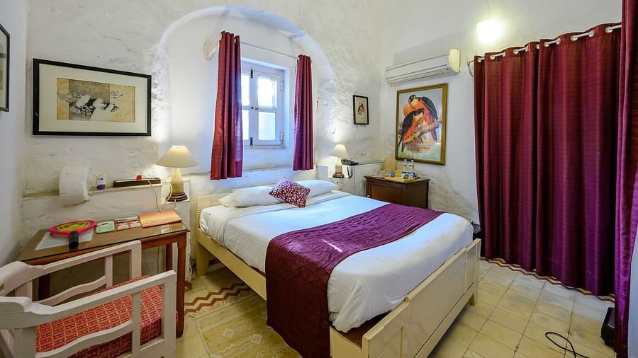 Hill Fort Kesroli 14th Century Alwar - interior view of Baaj Mahal - Garden View with queen size bed and purple curtains