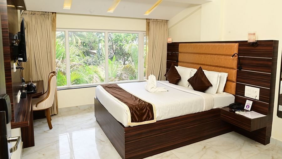 a double bed with a study table in front of it inside one of the rooms - VITS shanti solitaire, North Goa