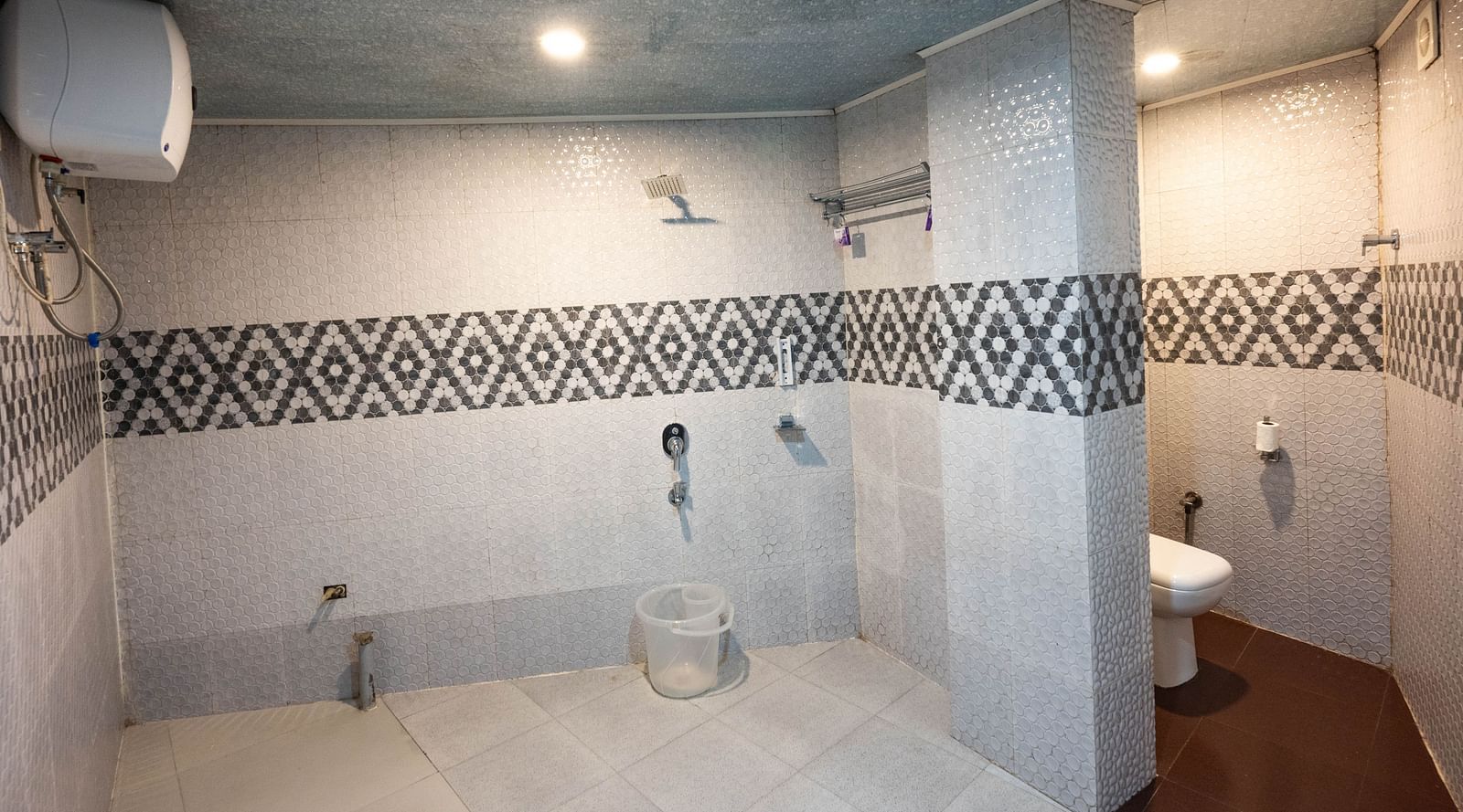 an image of a bathroom with a bucket and a water heater at Avianna New Mandala Hotel & Spa, Darjeeling