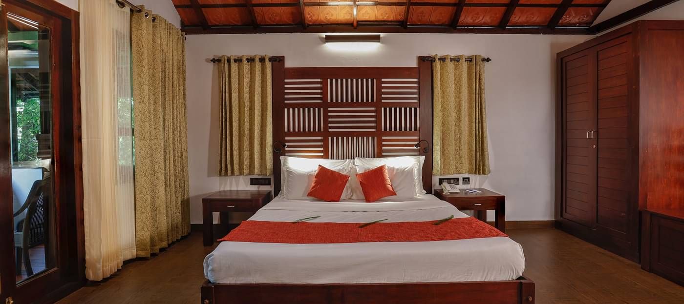 A front view of a bed placed in a room | Vythiri Resort, Wayanad