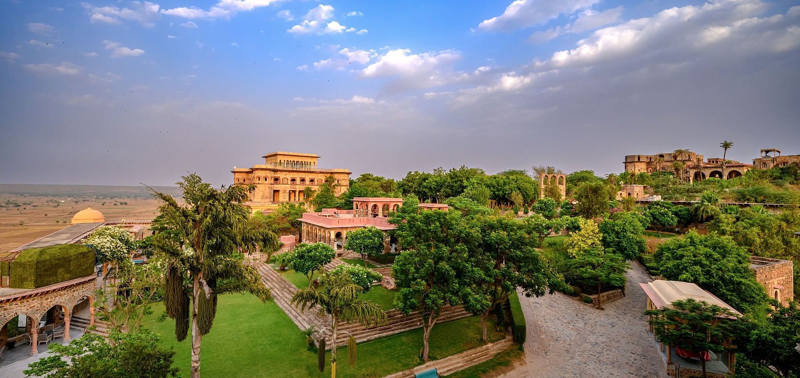 Facade view of Tijara Fort-Palace - 19th Century, Alwar with cloudy blue sky in the background.