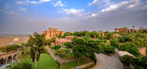 Facade view of Tijara Fort-Palace - 19th Century, Alwar with cloudy blue sky in the background.