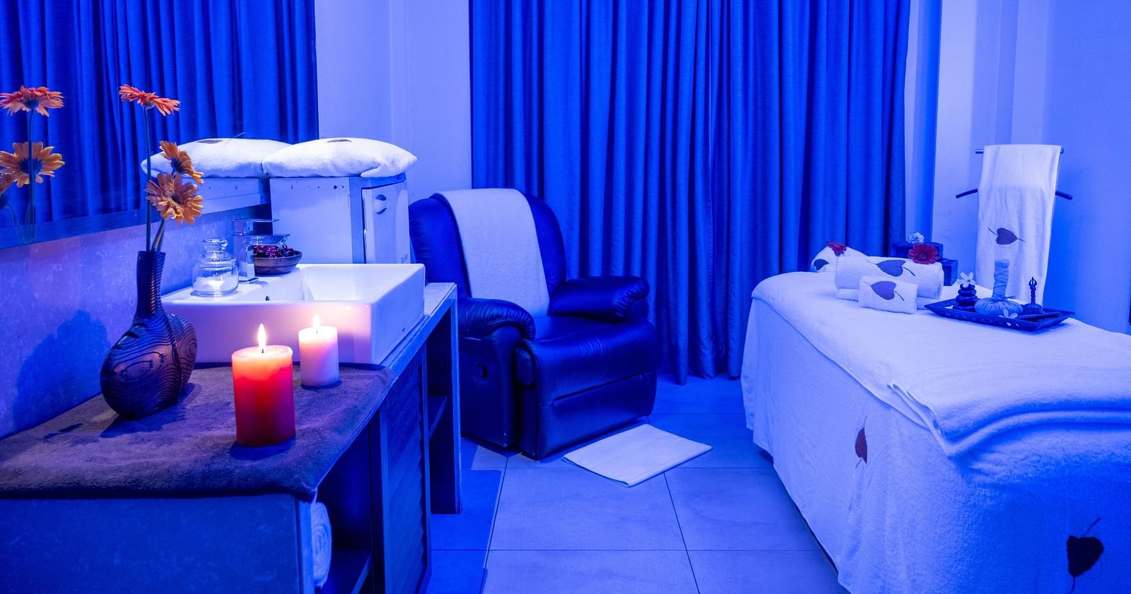 An image of a spa room with candles and massage chair at image of an event hall with tables and chairs at Grand Kakinada by GRT Hotels