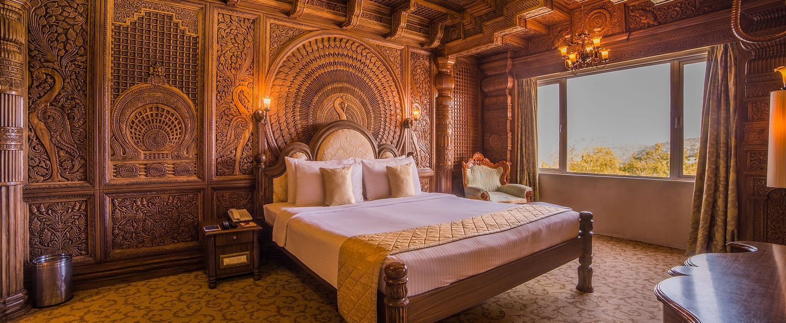 An opulent hotel room with traditional wooden carvings and panoramic views, offering a unique experience at  Sitara Luxury Hotel in Hyderabad near Ramoji Film City.