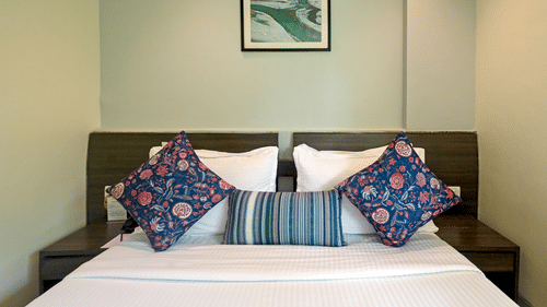Executive room with a large bed, spreads, pillows, and wall-art at Le Grande Mumbai.