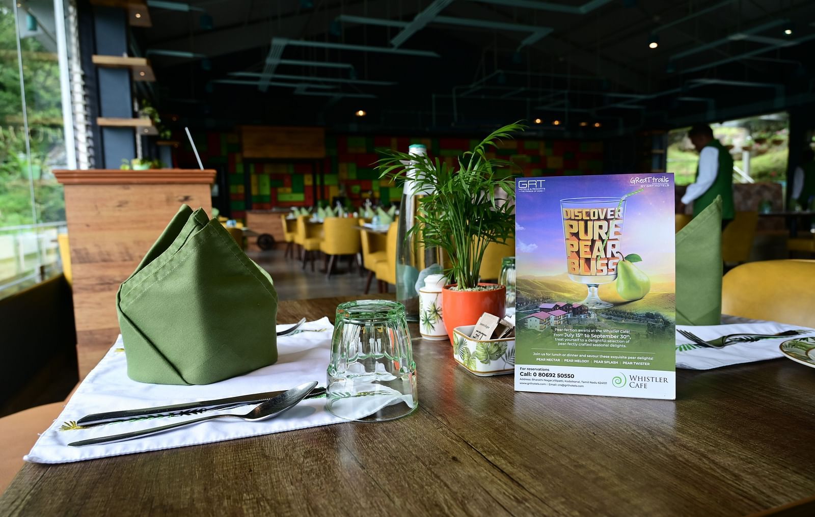 An image of a dining table with a glass, cutlery and decorative items - GReaT trails Kodaikanal by GRT Hotels