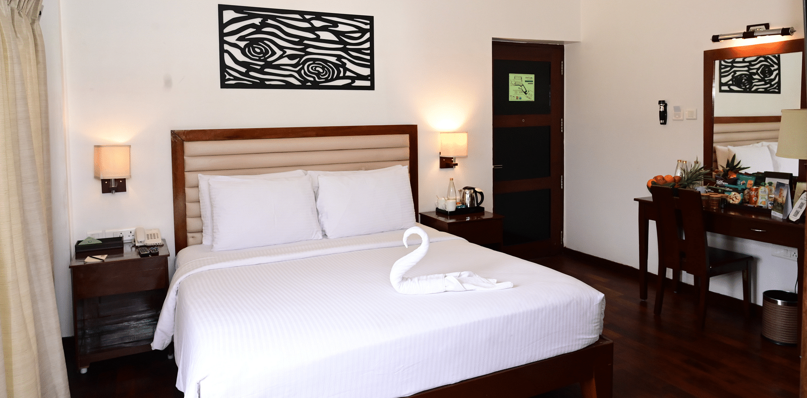 An image of a Rock Cabin Valley View with a king size bed, bed side table, lamps, ceiling fan, dressing table, and a chair - GReaT trails Kodaikanal by GRT Hotels