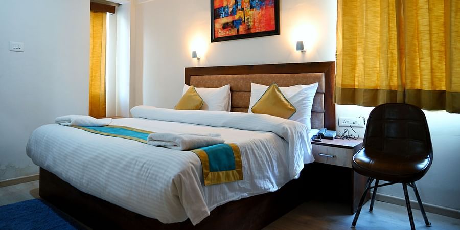 Hotel Panchvati Inn, Badrinath Badrinath The king size bedding with white sheets in the triple bed room - Panchvati Inn Badrinath
