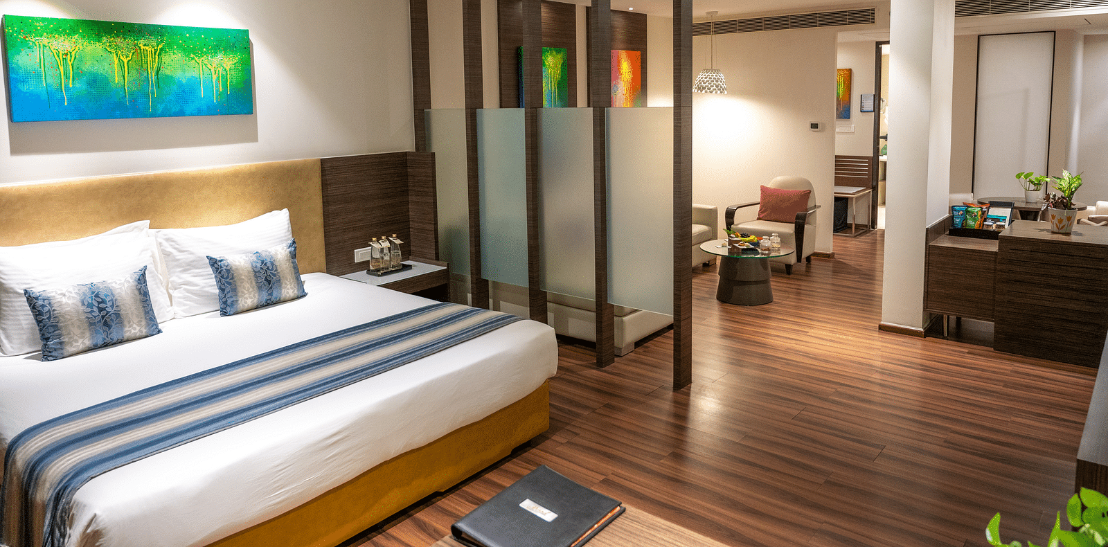 An image of a bedroom with a living space at  Grand Kakinada by GRT Hotels