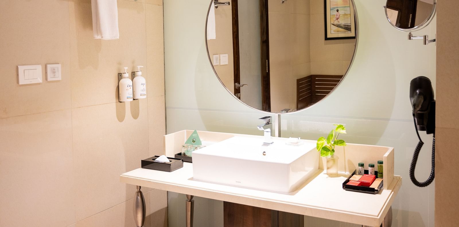 An image of a bathroom with A mirror and a hair dryer at  Grand Kakinada by GRT Hotels