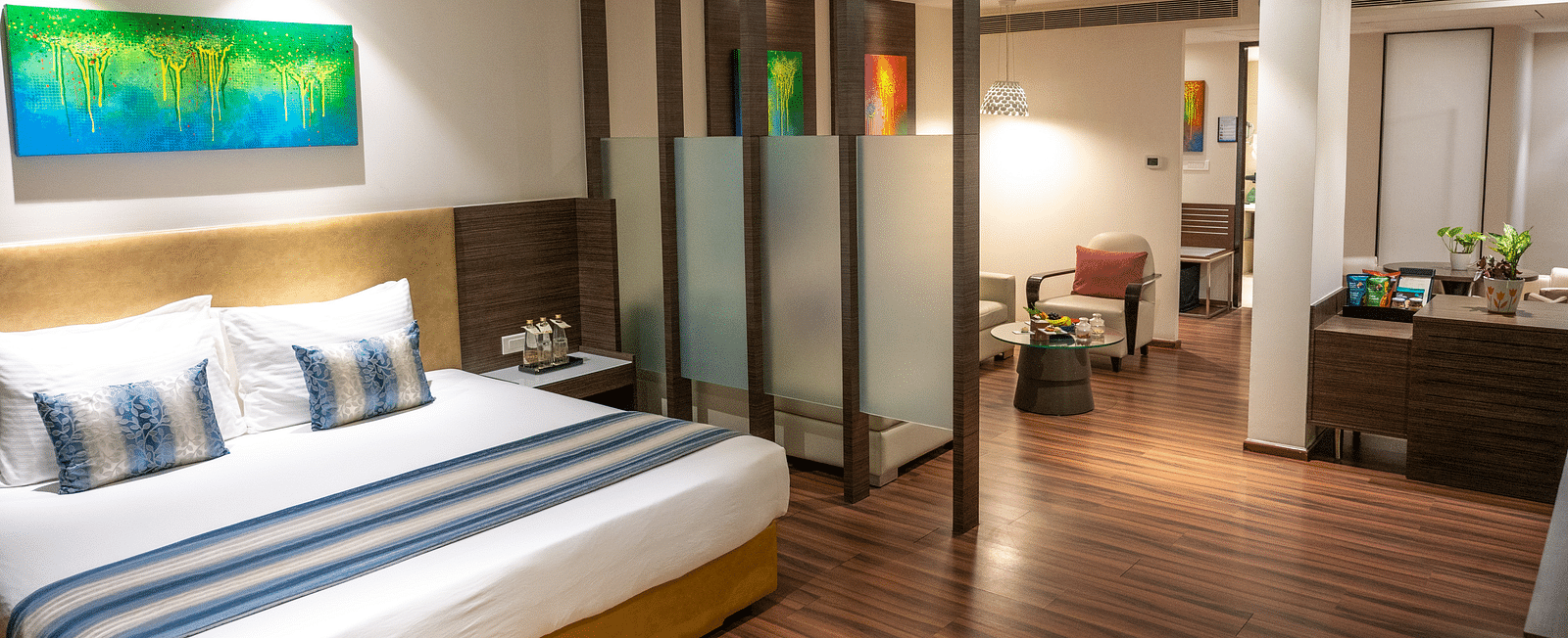 An image of a bedroom with a living space at  Grand Kakinada by GRT Hotels