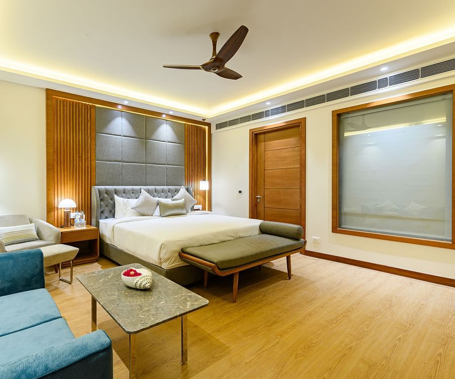 Interiors of one of the bedrooms at our presidential suite in Pushkar featuring a bed, a blue sofa and other furniture 5761