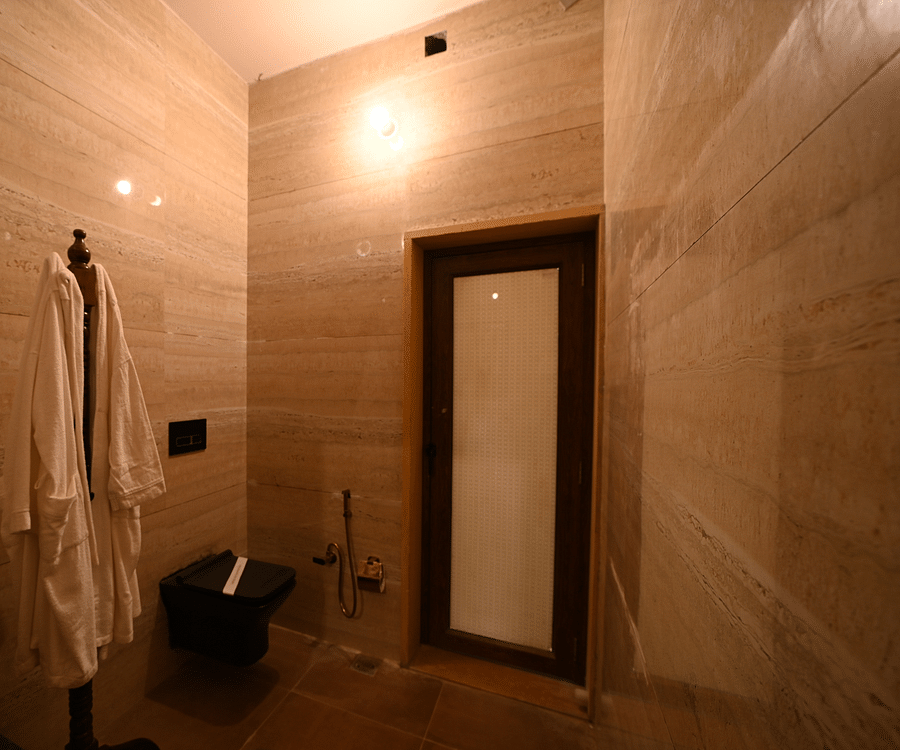 A bathrobe hung on a clothes stand inside the washroom - Karwaan Jaisalmer