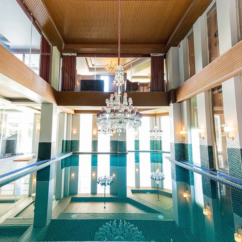 A pool where sunlight is hitting the area and there's a chandelier at the top - The Manor Luxury Hotel, Shimla