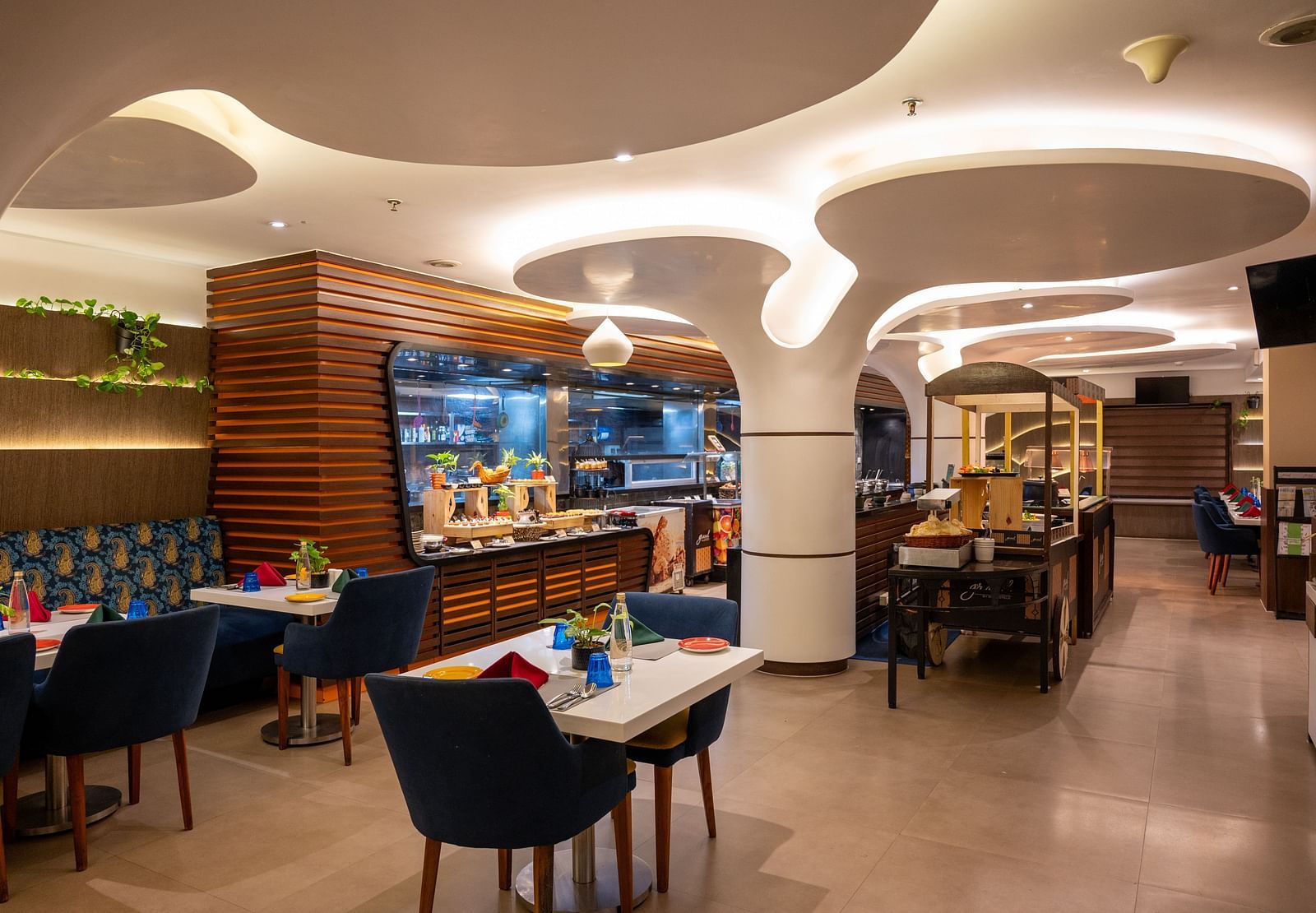 An image of a dining space with a designed ceiling at Grand Kakinada by GRT Hotels
