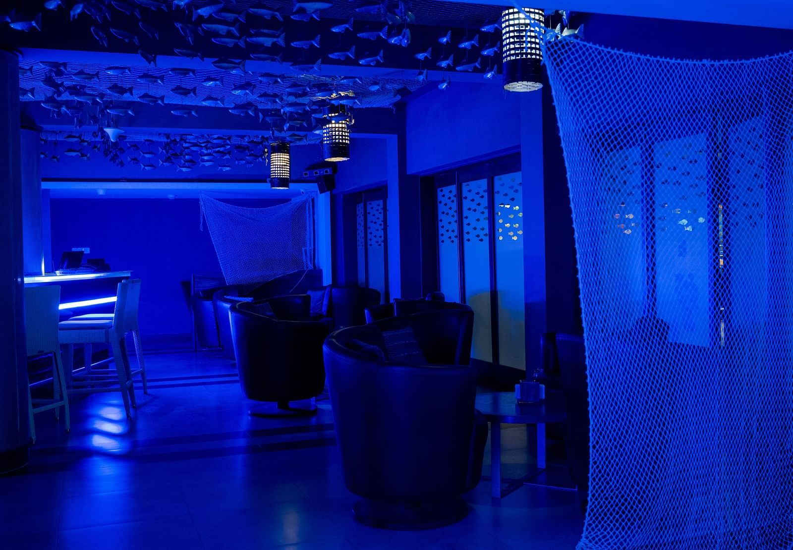 Image of seating space in the bar with cup shaped chair at image of an event hall with tables and chairs at Grand Kakinada by GRT Hotels