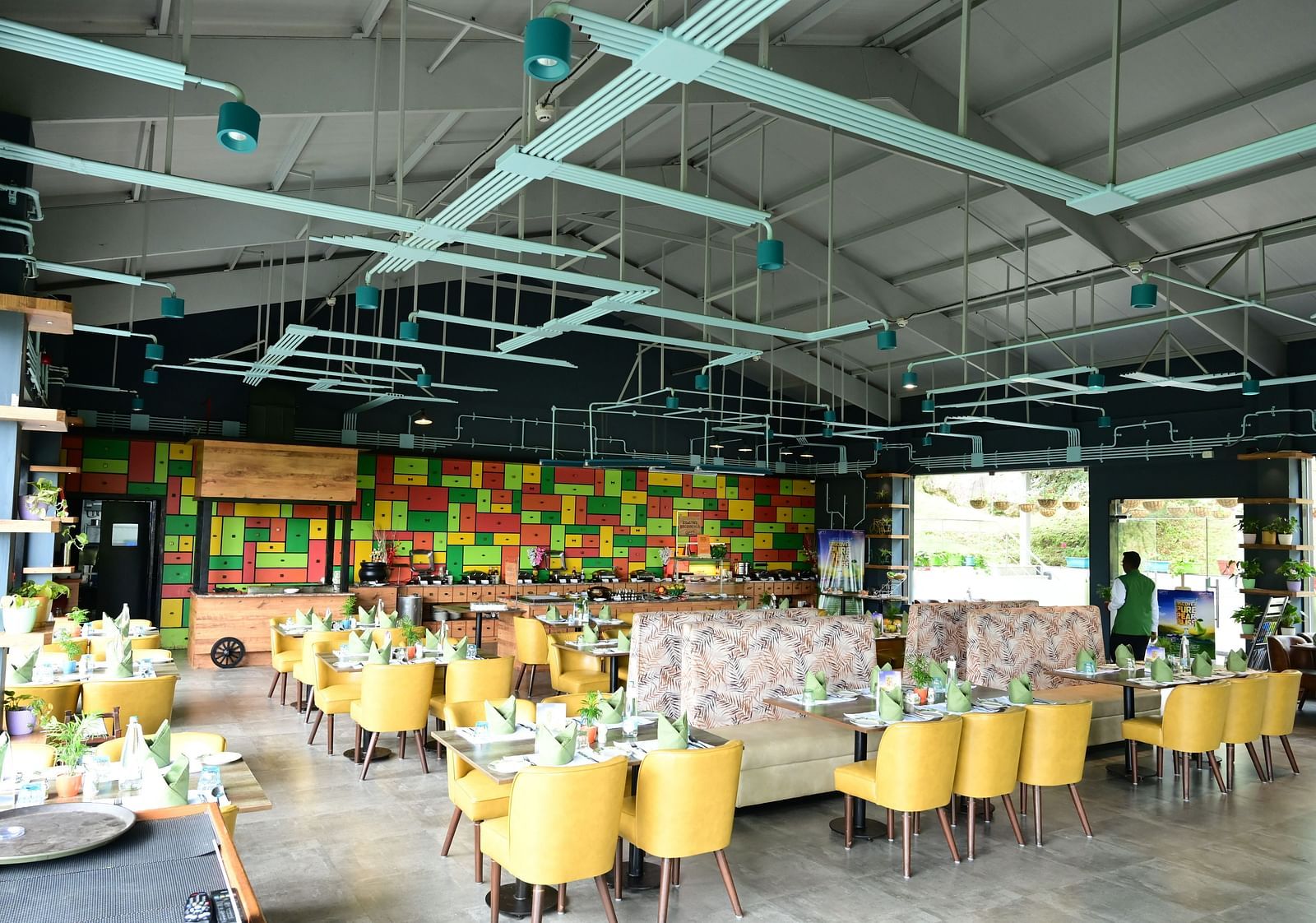 An image of a restaurant with seating arrangement, cutlery, and decorative items - GReaT trails Kodaikanal by GRT Hotels