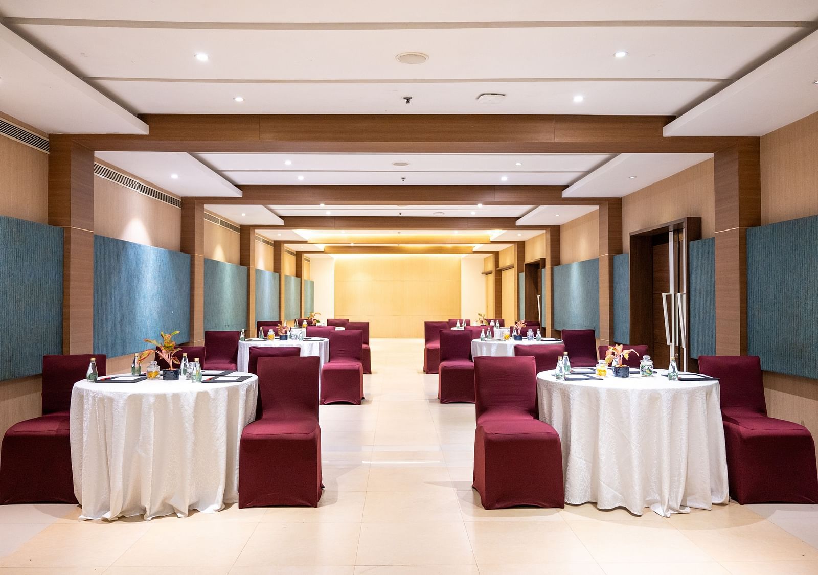 image of an event hall with tables and chairs at Grand Kakinada by GRT Hotels