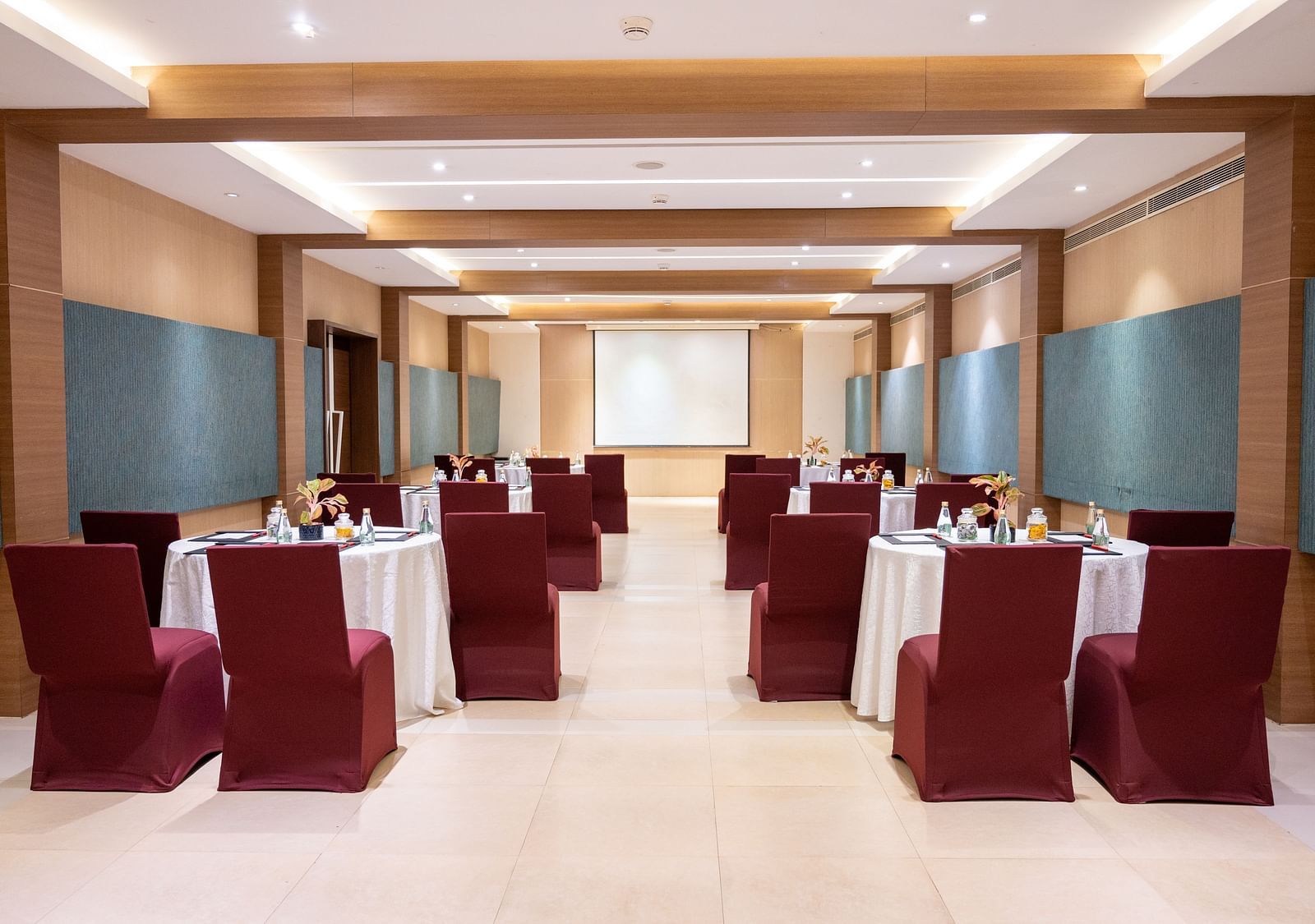 rear view of the hall with tables and chairs at Grand Kakinada by GRT Hotels