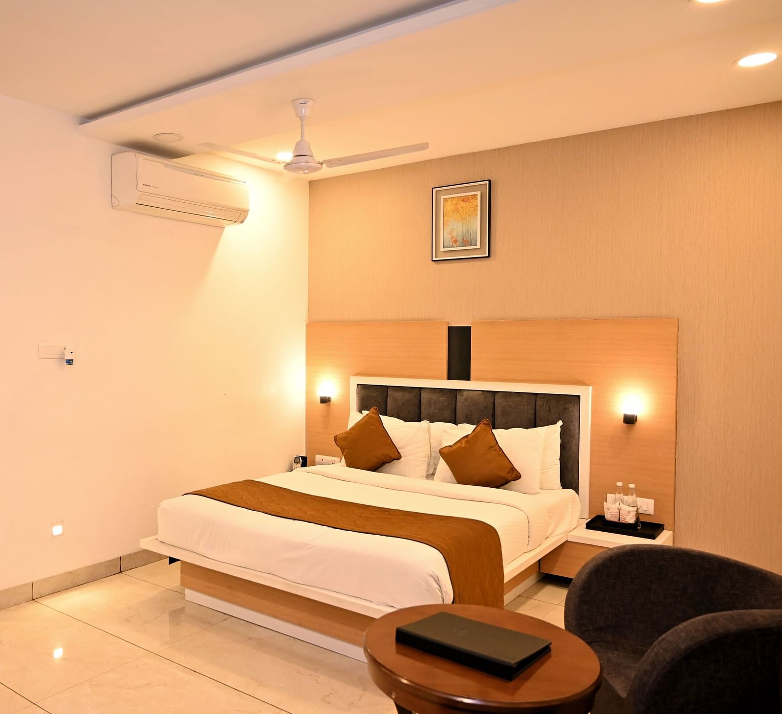 A stylish bedroom featuring a large bed with a green headboard and textured wall art - TGI Insignia, Bhopal